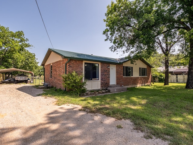 view of front of property featuring a front yard and a carport