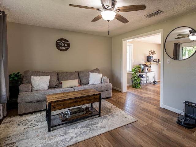 living room featuring a textured ceiling, ceiling fan, and hardwood / wood-style floors