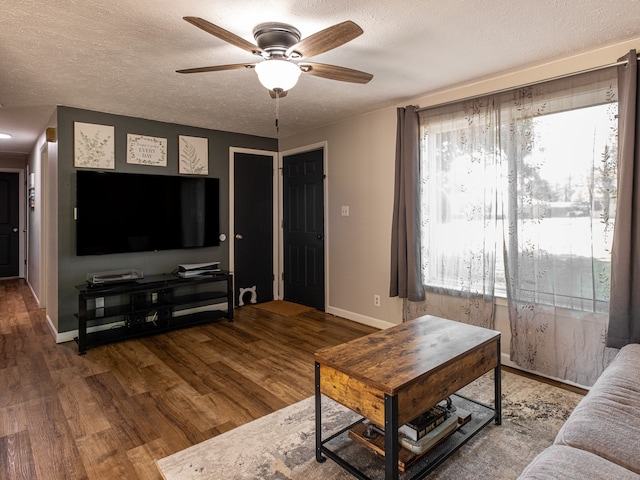 living room with a textured ceiling, hardwood / wood-style flooring, and ceiling fan