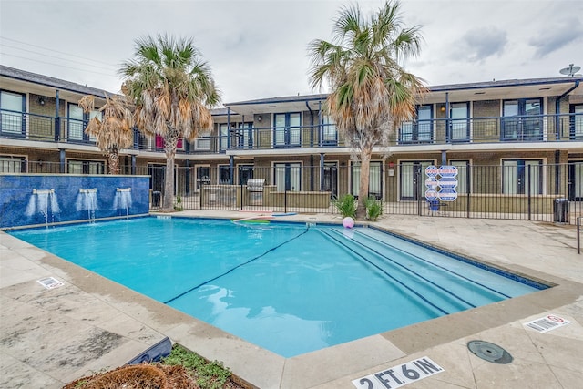 view of swimming pool with pool water feature