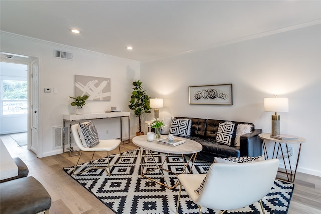 living room featuring ornamental molding and light hardwood / wood-style floors