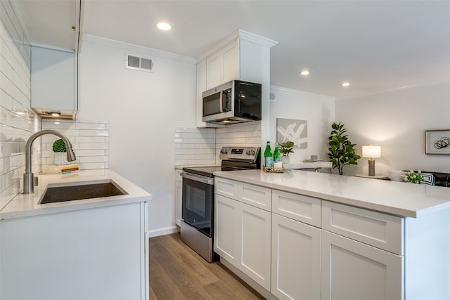 kitchen with stainless steel appliances, white cabinets, sink, crown molding, and light hardwood / wood-style flooring