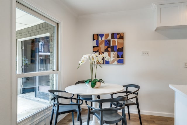 dining space featuring hardwood / wood-style flooring and crown molding