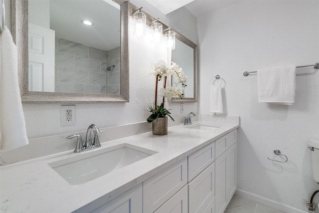 bathroom with a tile shower and vanity