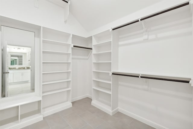 walk in closet with light tile patterned flooring and lofted ceiling