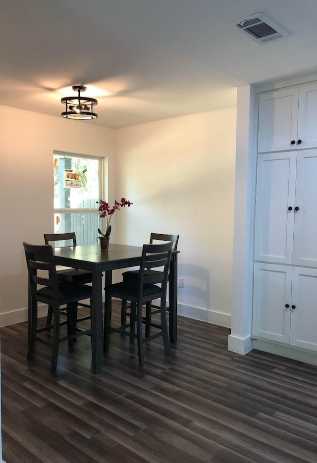 dining room with baseboards, visible vents, and dark wood-style flooring