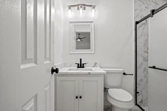 full bathroom featuring toilet, marble finish floor, a shower stall, and vanity