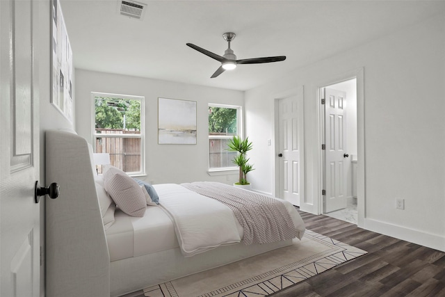 bedroom with multiple windows, dark wood finished floors, visible vents, and baseboards