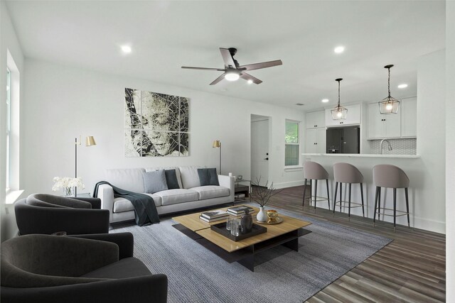 kitchen featuring dark wood-type flooring, pendant lighting, decorative backsplash, white cabinets, and appliances with stainless steel finishes