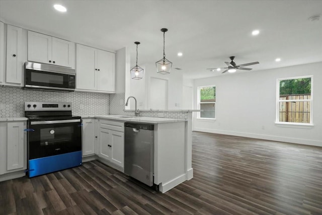 kitchen with white cabinets, appliances with stainless steel finishes, and a wealth of natural light