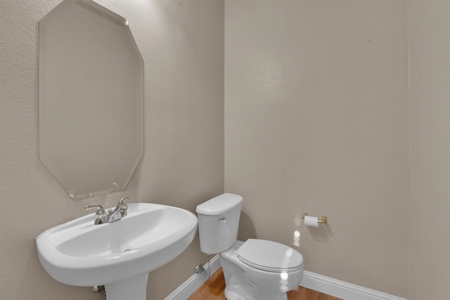 bathroom featuring toilet, hardwood / wood-style flooring, and sink