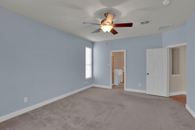 unfurnished bedroom featuring ceiling fan, ensuite bathroom, and light carpet