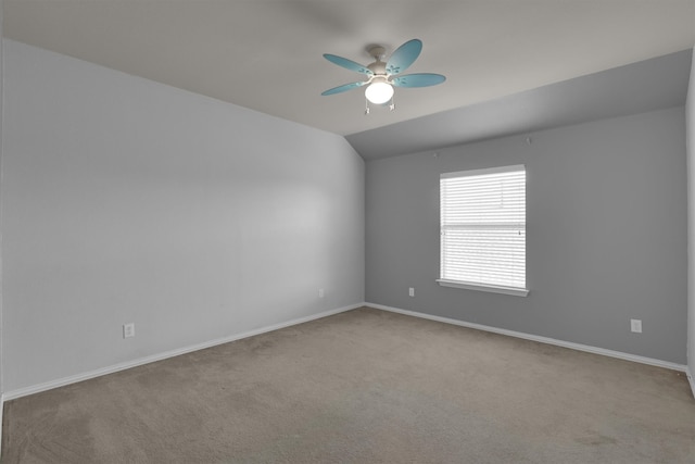 carpeted empty room featuring vaulted ceiling