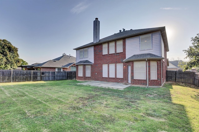 rear view of house with a lawn and a patio