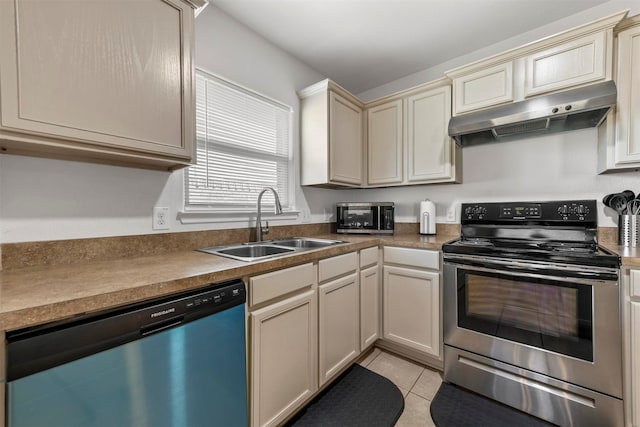 kitchen with light tile patterned floors, sink, cream cabinetry, extractor fan, and stainless steel appliances