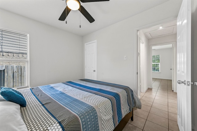 tiled bedroom featuring ceiling fan