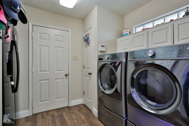 clothes washing area featuring washer and dryer, cabinets, and dark hardwood / wood-style floors