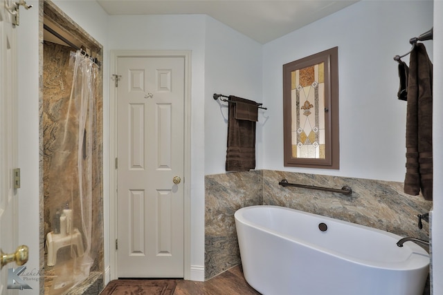 bathroom with hardwood / wood-style floors and a washtub