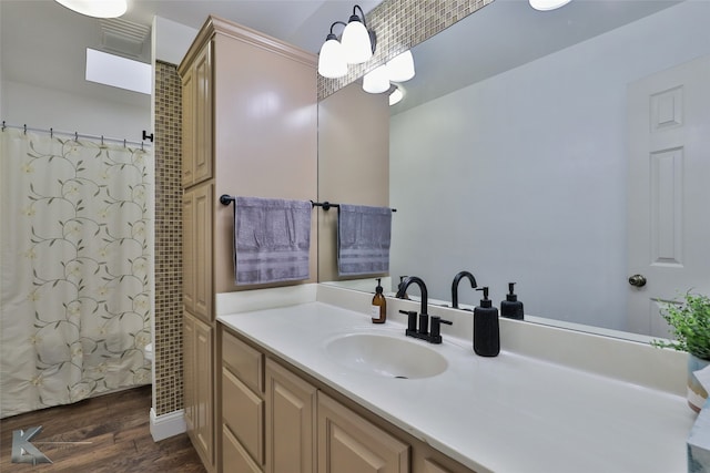 bathroom featuring walk in shower, hardwood / wood-style flooring, and vanity