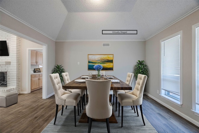 dining area with hardwood / wood-style floors, vaulted ceiling, and a healthy amount of sunlight