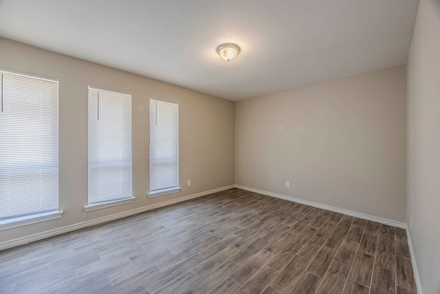 unfurnished room with dark hardwood / wood-style flooring