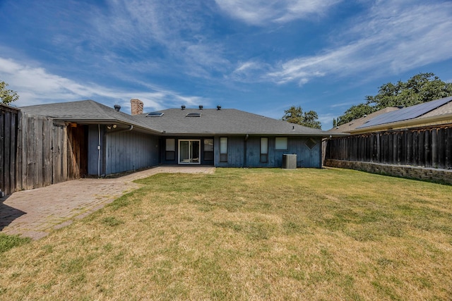 back of property with a lawn and central AC