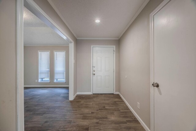 entrance foyer with dark hardwood / wood-style flooring, a textured ceiling, and ornamental molding