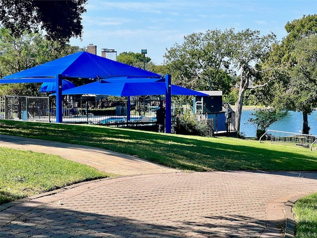 view of home's community with a lawn and a water view