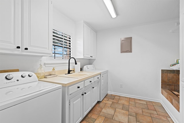 clothes washing area featuring independent washer and dryer, cabinets, and sink