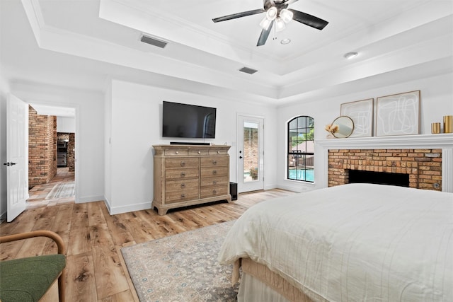 6005 Englishoak Dr, Arlington, TX 76016 - bedroom featuring a brick fireplace, a tray ceiling, access to outside, wood finished floors, and ornamental molding