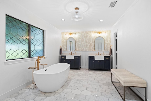 6005 Englishoak Dr, Arlington, TX 76016 - full bathroom featuring crown molding, a freestanding bath, two vanities, and recessed lighting