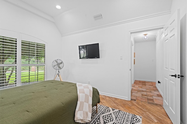 bedroom with lofted ceiling and light wood-type flooring