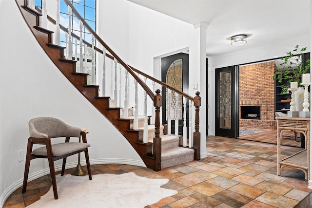 6005 Englishoak Dr, Arlington, TX 76016 - entrance foyer featuring stairway, stone tile floors, crown molding, and a brick fireplace
