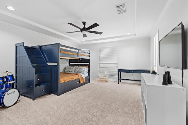 carpeted bedroom featuring a tray ceiling, crown molding, and ceiling fan