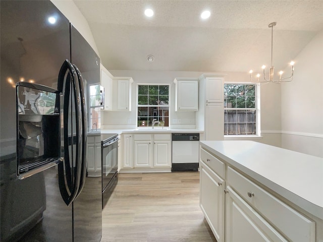 kitchen featuring decorative light fixtures, black appliances, an inviting chandelier, white cabinets, and light hardwood / wood-style floors