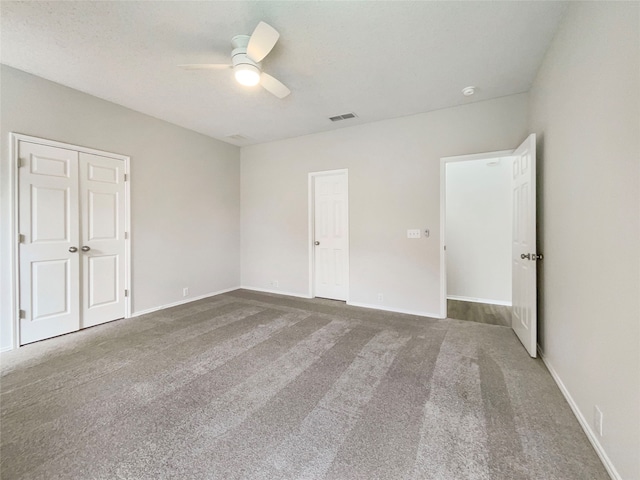 unfurnished bedroom with ceiling fan and carpet