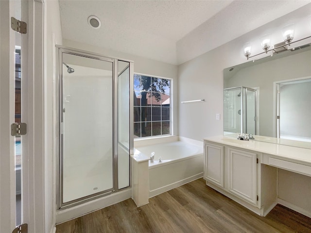 bathroom featuring vanity, hardwood / wood-style floors, independent shower and bath, and a textured ceiling