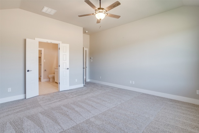 unfurnished bedroom with ensuite bathroom, light colored carpet, lofted ceiling, and ceiling fan