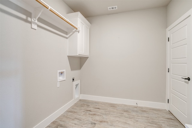 laundry room with hookup for an electric dryer, light hardwood / wood-style floors, washer hookup, and cabinets