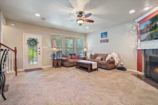 living room featuring ceiling fan, carpet floors, and a fireplace