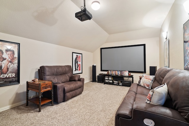 carpeted home theater room with vaulted ceiling