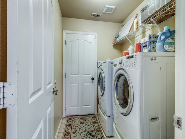 laundry area with independent washer and dryer and light tile patterned flooring