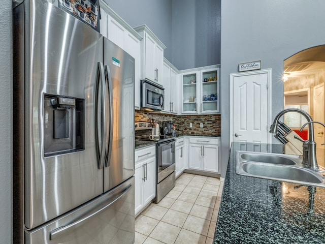 kitchen featuring white cabinets, backsplash, stainless steel appliances, sink, and light tile patterned flooring