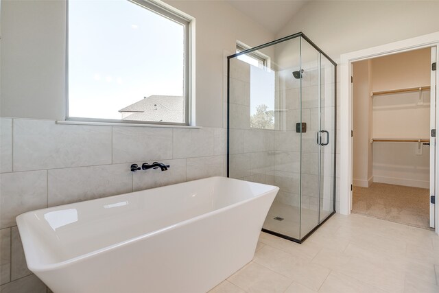 bathroom with tile walls, vaulted ceiling, and a healthy amount of sunlight