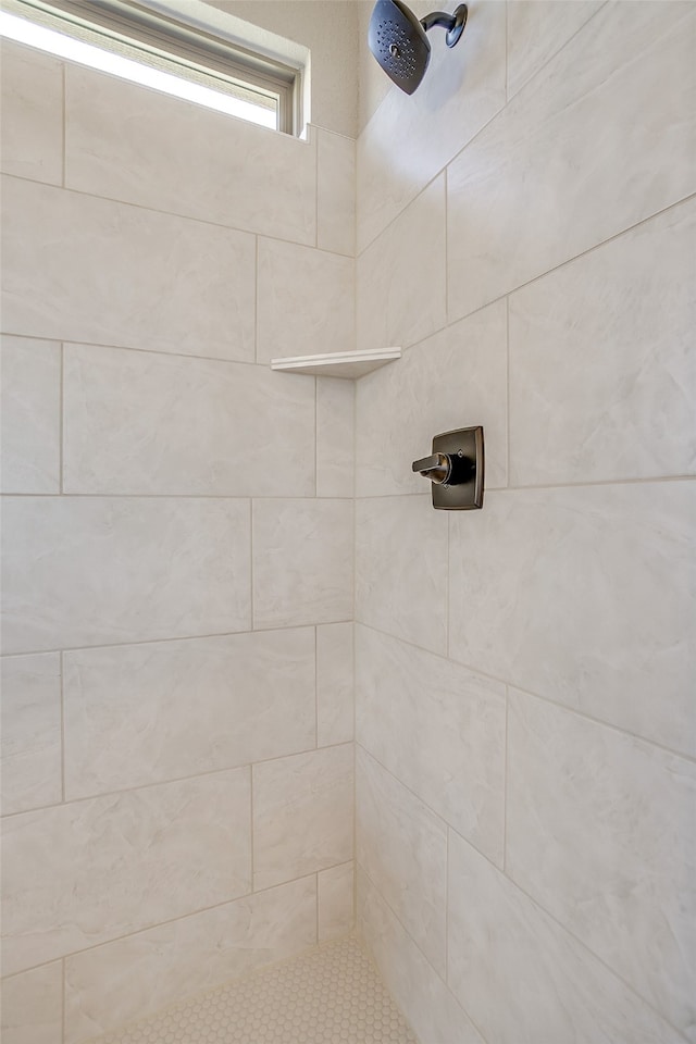 interior details with a tile shower