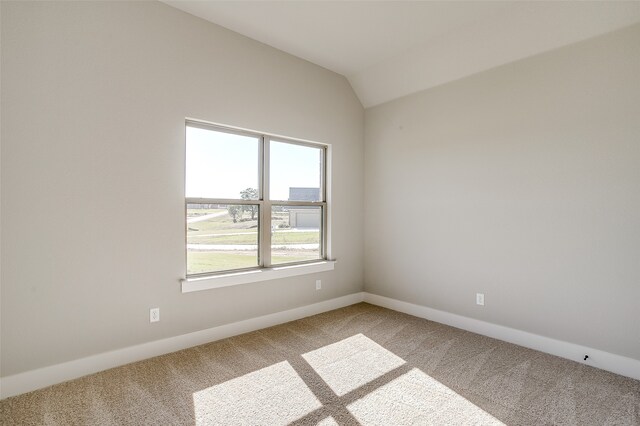 unfurnished room with carpet flooring and lofted ceiling