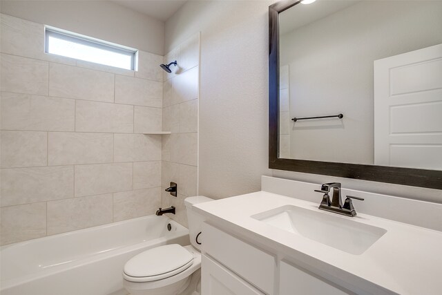 full bathroom with vanity, tiled shower / bath combo, and toilet