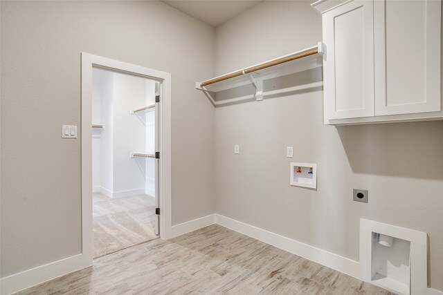 clothes washing area featuring cabinets, washer hookup, hookup for an electric dryer, and light wood-type flooring