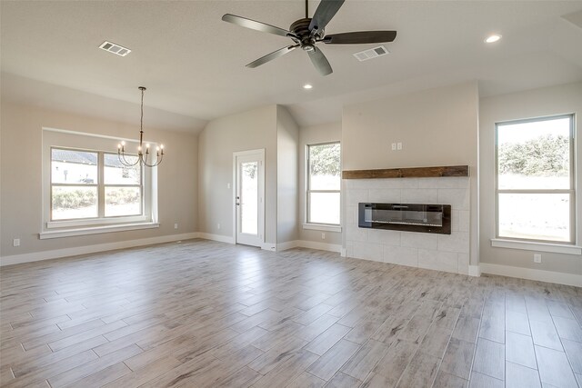 unfurnished living room with a fireplace, light wood-type flooring, and plenty of natural light