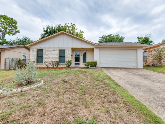 single story home featuring a garage and a front lawn